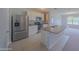 The kitchen features stainless steel appliances, white cabinets, an island, and tile floors, offering a modern look at 5263 Bear Corn Run, Port Orange, FL 32128