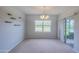 Bright living room offers natural light from a large window and elegant chandelier at 5263 Bear Corn Run, Port Orange, FL 32128