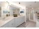 Bright bathroom featuring double sinks, updated vanity, framed mirror, shower and tub with coordinated decor at 5300 S Atlantic Ave # 11302, New Smyrna Beach, FL 32169