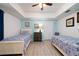 Nautical-themed bedroom featuring twin beds, light blue walls, and stylish decor, creating a serene and inviting space at 5300 S Atlantic Ave # 11302, New Smyrna Beach, FL 32169