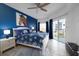 Serene bedroom featuring a blue accent wall, a comfortable king-size bed, and private balcony access at 5300 S Atlantic Ave # 11302, New Smyrna Beach, FL 32169