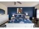 The main bedroom of the house with blue accent wall, art, desk, and king size bed at 5300 S Atlantic Ave # 11302, New Smyrna Beach, FL 32169