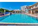 Large in-ground pool with ample lounge chairs, shaded area, and views of the surrounding property at 5300 S Atlantic Ave # 11302, New Smyrna Beach, FL 32169