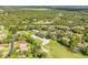 Aerial view showcasing homes in a golf course community with lush greenery and mature trees in a serene setting at 544 Bottlebrush Ct, New Smyrna Beach, FL 32168