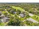 Aerial view of a beautiful home with a lush green lawn, mature trees, and a nearby golf course at 544 Bottlebrush Ct, New Smyrna Beach, FL 32168
