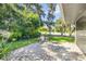 Charming outdoor patio with stone pavers, lush landscaping, and seating area for relaxing or entertaining at 544 Bottlebrush Ct, New Smyrna Beach, FL 32168