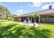 Lush backyard featuring a patio, screened-in porch, mature trees, and well-maintained landscaping at 544 Bottlebrush Ct, New Smyrna Beach, FL 32168