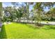 Lush backyard with mature trees and manicured lawn, featuring a relaxing patio at 544 Bottlebrush Ct, New Smyrna Beach, FL 32168