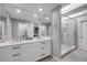 Bathroom showcasing double sinks with white cabinets, a shower with skylight, and gray walls at 544 Bottlebrush Ct, New Smyrna Beach, FL 32168