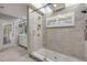 Walk-in shower with skylight, glass door, tiled walls, and modern fixtures at 544 Bottlebrush Ct, New Smyrna Beach, FL 32168