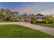 Inviting brick home with well-maintained lawn, lovely landscaping, and a spacious driveway, illuminated by warm lighting at 544 Bottlebrush Ct, New Smyrna Beach, FL 32168