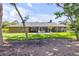 Lush backyard with mature trees, well-maintained lawn, covered patio, and peaceful outdoor setting at 544 Bottlebrush Ct, New Smyrna Beach, FL 32168
