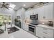 Bright kitchen with white cabinetry, stainless steel appliances, skylight and ample counter space at 544 Bottlebrush Ct, New Smyrna Beach, FL 32168