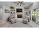 A cozy seating area facing the painted fireplace with built-in shelves and glass doors leading to the backyard at 544 Bottlebrush Ct, New Smyrna Beach, FL 32168