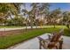 Inviting patio with Adirondack chairs overlooks the lush green lawn and mature trees at 544 Bottlebrush Ct, New Smyrna Beach, FL 32168