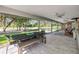 Outdoor dining area on screened patio with lush backyard and golf course views at 544 Bottlebrush Ct, New Smyrna Beach, FL 32168