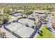 Aerial view of well-maintained tennis courts surrounded by lush greenery at 544 Bottlebrush Ct, New Smyrna Beach, FL 32168
