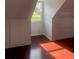 An attic room featuring dark hardwood floors and a small window bringing in natural light at 5832 Michelle Ln, Sanford, FL 32771