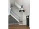 Bright entryway with hardwood floors, staircase, modern light fixture, and a stylish front door at 5832 Michelle Ln, Sanford, FL 32771