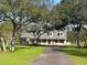 Charming two-story home with mature trees and well-maintained front yard and a long, winding driveway at 5832 Michelle Ln, Sanford, FL 32771