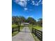 Picturesque view of a gated property featuring a long driveway, lush greenery, and a charming home at 5832 Michelle Ln, Sanford, FL 32771