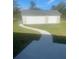 View of the large two-car garage and concrete walkway from the backyard on a sunny day at 5832 Michelle Ln, Sanford, FL 32771