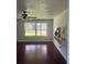 Living room featuring hardwood floors, wall shelving, and a large window with backyard views at 5832 Michelle Ln, Sanford, FL 32771