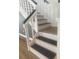 Stylish staircase with white and stained wood, featuring decorative wall accents and stair runners at 5832 Michelle Ln, Sanford, FL 32771