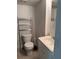 Small bathroom with a toilet, sink, and metal shelving at 585 Washington St, New Smyrna Beach, FL 32168