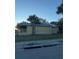 View of charming yellow single-story home surrounded by chain link fence and mature tree at 585 Washington St, New Smyrna Beach, FL 32168