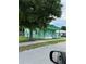 Exterior view of a charming green bungalow with a covered front porch and chain-link fence at 585 Washington St, New Smyrna Beach, FL 32168