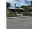 Exterior of a home with yellow siding, a metal roof, and a chain link fence at 585 Washington St, New Smyrna Beach, FL 32168