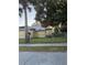 Exterior view of a yellow home with a metal roof and fenced yard at 585 Washington St, New Smyrna Beach, FL 32168
