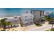 Aerial view of a modern beachfront home with a gray roof, multiple balconies, and ocean access at 6883 S Atlantic Ave, New Smyrna Beach, FL 32169