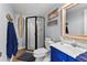 Nautical-themed bathroom featuring a glass shower, blue vanity, and decorative surfboard at 6883 S Atlantic Ave, New Smyrna Beach, FL 32169