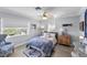 Bright bedroom with two windows, ceiling fan, and stylish blue and white decor at 6883 S Atlantic Ave, New Smyrna Beach, FL 32169