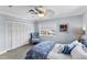 Bedroom with a ceiling fan, neutral walls, white louvered closet and matching chair at 6883 S Atlantic Ave, New Smyrna Beach, FL 32169