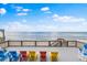 Inviting oceanfront deck with colorful Adirondack chairs overlooking the beach and ocean at 6883 S Atlantic Ave, New Smyrna Beach, FL 32169