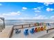 Expansive deck featuring colorful Adirondack chairs with ocean views and beach access at 6883 S Atlantic Ave, New Smyrna Beach, FL 32169