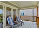 Inviting covered balcony featuring comfortable striped seating and a cozy outdoor ambiance at 6956 Turtlemound Rd, New Smyrna Beach, FL 32169