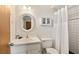 Clean bathroom featuring a white vanity, toilet, and shower with white tiling and curtain at 6956 Turtlemound Rd, New Smyrna Beach, FL 32169