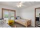 Bright bedroom offering twin beds, a yellow side table, and a glimpse into the adjacent kitchen area at 6956 Turtlemound Rd, New Smyrna Beach, FL 32169