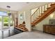 Inviting foyer with tile and carpet, complemented by stairs leading to the upper levels of the home at 6956 Turtlemound Rd, New Smyrna Beach, FL 32169