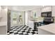 Bright kitchen featuring black and white checkered flooring, stainless steel appliances, and convenient outdoor access at 6956 Turtlemound Rd, New Smyrna Beach, FL 32169