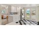 Well-lit kitchen equipped with stainless steel refrigerator and a charming backsplash, adjacent to a cozy bedroom at 6956 Turtlemound Rd, New Smyrna Beach, FL 32169