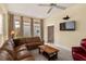 Cozy living room featuring a comfortable leather sofa, a mounted TV, and ample natural light at 6956 Turtlemound Rd, New Smyrna Beach, FL 32169