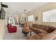 Open-concept living room with leather furniture, a bar area, natural light, and an inviting atmosphere at 6956 Turtlemound Rd, New Smyrna Beach, FL 32169