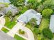 Aerial view of home with mature landscaping, circular driveway, and large concrete parking pad at 757 Hunt Club Trl, Port Orange, FL 32127