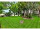 Expansive backyard with lush green lawn, mature trees and view of the lake at 757 Hunt Club Trl, Port Orange, FL 32127