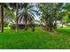 Manicured lawn and mature trees accentuate the backyard and lanai at 757 Hunt Club Trl, Port Orange, FL 32127